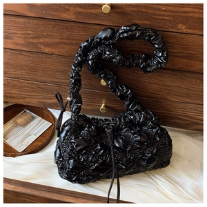 Gros plan du sac nuage plissé noir avec texture brillante et cordons de serrage décoratifs