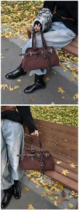 Detail of dark brown matte tote bag with leather straps and decorative scarf in park setting