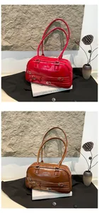 Close-up of vintage PU leather underarm bags in red and brown with buckle details