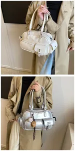 Detail view of multi-pocket PU leather Boston bags in white and silver colors