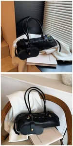 Black leather baguette bag with side strap detail and detachable small pouch accessory