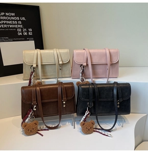 Detailed view of four vintage flap crossbody bags in beige, pink, brown, and black colors