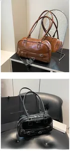 Detailed view of vintage PU leather shoulder bag with buckle straps and side bow accent