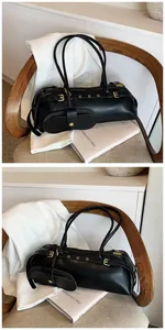 Detail of black faux leather baguette bag with metal buckle and mini pouch attachment