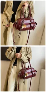 Detail of dark red faux leather bowling bag with utility pockets and shoulder strap