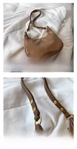 Détail de la bandoulière en cuir réglable avec œillets métalliques et rivets sur un sac brun