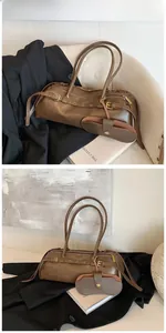 Detail of vintage brown leather cylinder bag with multi-buckle straps and detachable pouch