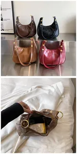 Vue détaillée du grand intérieur avec objets du quotidien dans un sac en cuir plissé