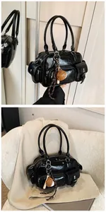 Detail of black glossy PU leather bowling bag with multiple pockets and mushroom charm