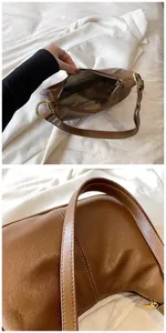 Détail du sac en cuir ciré marron avec surpiqûres et poche intérieure zippée