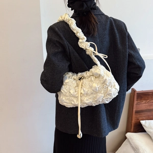 Sac nuage plissé blanc avec large bandoulière et détails de cordon sur le modèle