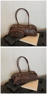 Detail of vintage dark brown baguette bag with leather strap and hanging mini pouch