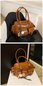 Close-up of brown PU leather Boston bag with creative baseball glove charm and pockets