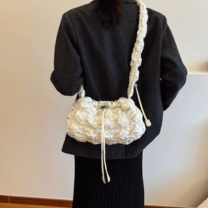 Sac nuage blanc plissé au fini perlé porté par une femme dans un style moderne
