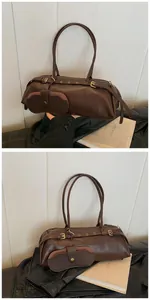 Detail of dark brown leather baguette bag with matching small hanging pouch and metal buckle