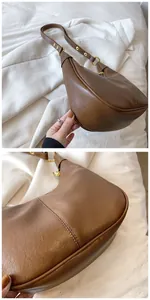 Détails du sac demi-lune en cuir ciré avec boucle métallique dorée et texture de surface