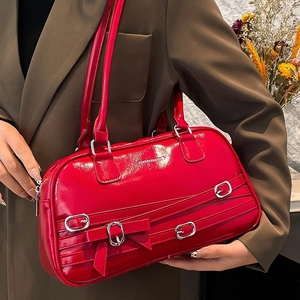 Red glossy PU leather shoulder bag with silver buckles and bows in a retro minimalist style