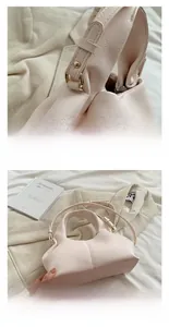 Details einer hellrosa Ledertasche mit Goldbeschlägen und elegantem Faltendesign