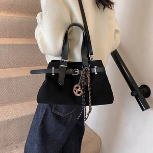 Frosted black tote bag with silver buckle and decorative pendants shown on person