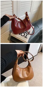 Détail de sacs selle rétro en cuir ciré bordeaux et marron avec ferrures dorées