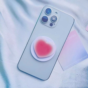 Detail der pinken Herz-Handyhalterung mit Farbverlauf auf blauem Smartphone
