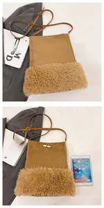 Detail of suede bucket bag with faux shearling trim and adjustable strap buckle