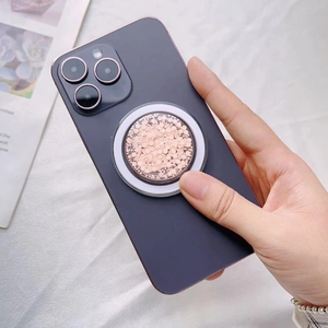 Close-up of pink glitter MagSafe ring holder on purple phone with shimmering sequins