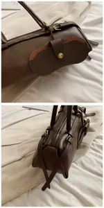 Detail of dark brown leather baguette bag featuring a matching detachable eyewear pouch