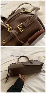 Close-up of litchi texture brown leather and gold hardware detail on baguette bag