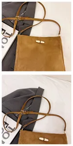 Detail of brown faux suede bucket bag featuring horn button closure and adjustable strap