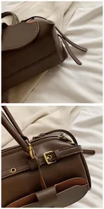 Detail view of brown leather baguette bag showing golden twist lock and suede lining