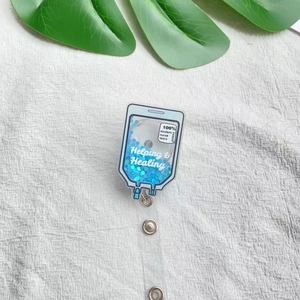Close-up of IV bag shaped badge reel with blue flowing glitter and Healing text