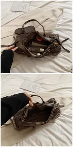 Detailed view of dark brown baguette bag showing spacious interior with striped lining