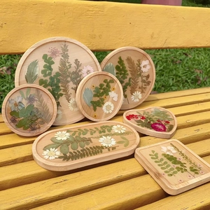 Macro detail of handmade resin wooden tray featuring real dried flowers and floral specimens