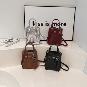 Mini rectangular tote bags in four colors with glossy finish and heart pendant detail
