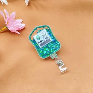 Detail of glitter fluid badge reel with green alien blood bag and volunteer donor sticker