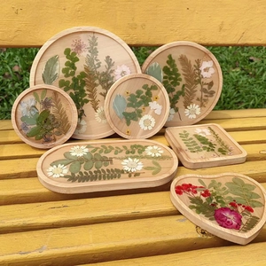 Detailed set of handmade wooden resin trays with real dried flowers in diverse shapes