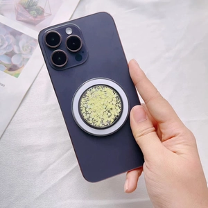 Close-up of yellow glitter MagSafe phone grip with magnetic ring on purple iPhone