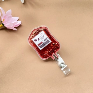 Macro detail of acrylic blood bag badge reel with red glitter and fuel label