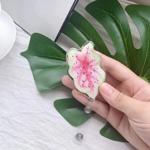 Detail of leaf-shaped acrylic badge reel with natural pink and green plant patterns