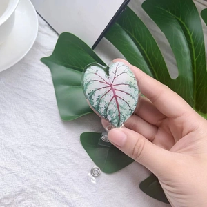 Detail of heart-shaped acrylic badge reel with tropical leaf pattern and pvc strap