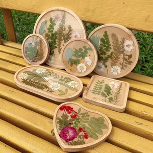 Macro detail of various shaped wooden coasters with real dried flowers and resin