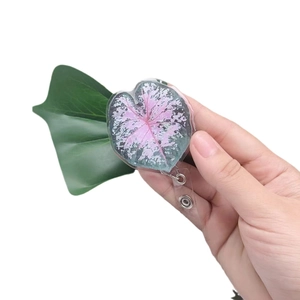 Acrylic leaf-shaped retractable badge holder with pink and green caladium pattern