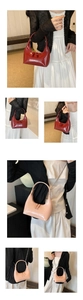 Gros plan de sacs demi-lune en cuir verni brillant avec double zip et bandoulières