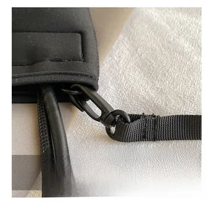 Detail of the high-quality hook and woven strap on a black stylish envelope chain bag