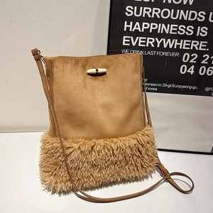 Brown suede and faux fur bucket bag with tassel, horn buckle, and leather shoulder strap