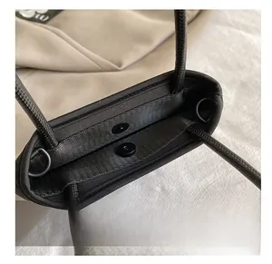 Detailed close-up of a nylon handbag featuring a secure black magnetic buckle closure