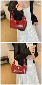 Vue détaillée du sac croissant en cuir verni bordeaux avec finition miroir et fermeture éclair