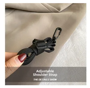 Detail of adjustable black nylon shoulder strap with plastic hook and weaving texture