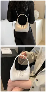 Sac croissant en cuir blanc minimaliste porté avec un costume gris moderne